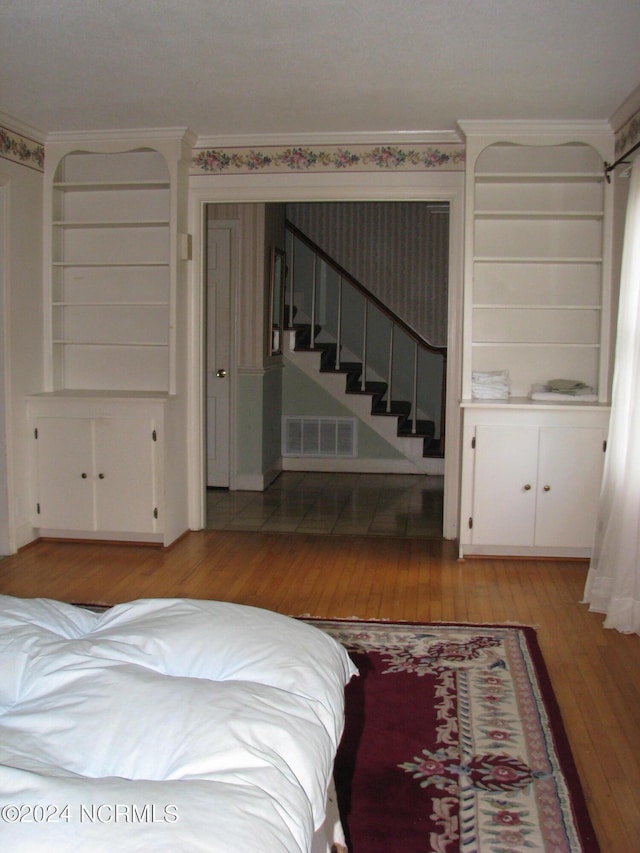 bedroom with crown molding and light wood-type flooring