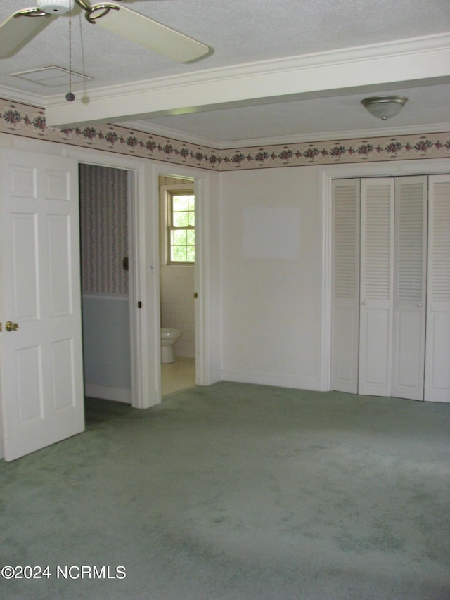 unfurnished bedroom with a textured ceiling, ceiling fan, crown molding, and light carpet