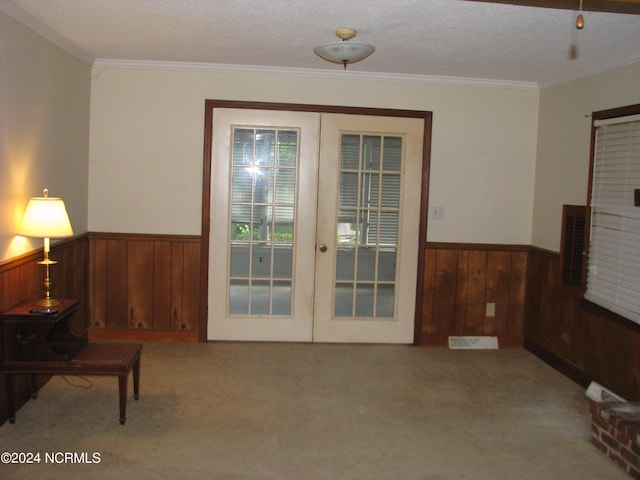 entryway with light carpet, french doors, and crown molding