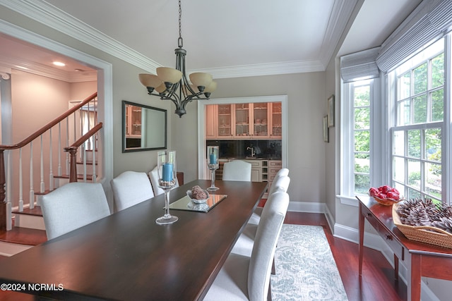 dining area with a wealth of natural light, dark wood-type flooring, an inviting chandelier, and crown molding