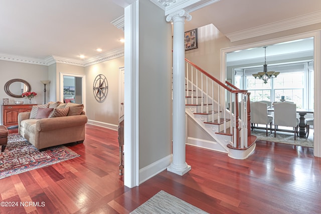 stairs featuring a notable chandelier, ornamental molding, dark hardwood / wood-style flooring, and ornate columns