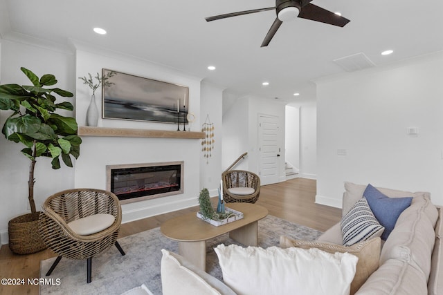 living room featuring crown molding, ceiling fan, and light wood-type flooring