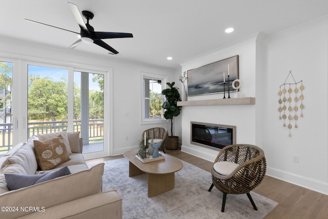 living room with crown molding, ceiling fan, and wood-type flooring