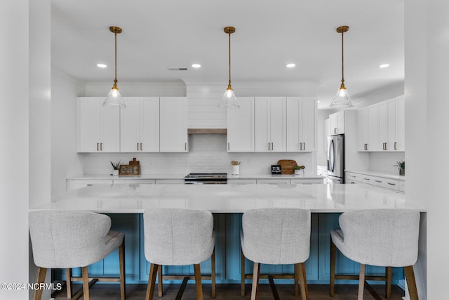 kitchen featuring white cabinets, light stone counters, appliances with stainless steel finishes, and tasteful backsplash