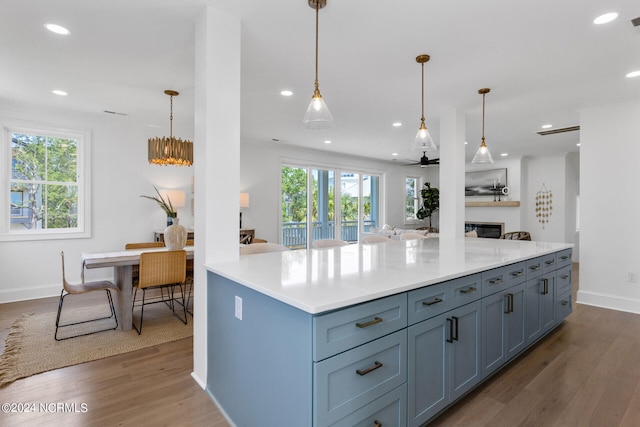 kitchen with wood-type flooring, decorative light fixtures, plenty of natural light, and ceiling fan