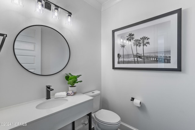 bathroom with vanity, toilet, and crown molding