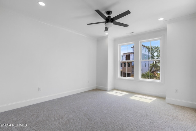 carpeted spare room featuring ceiling fan and crown molding