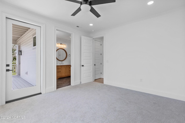 unfurnished bedroom with ceiling fan, sink, ensuite bathroom, light colored carpet, and ornamental molding