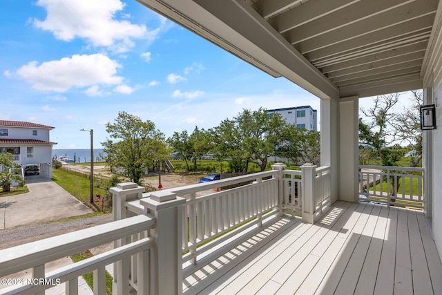 wooden deck with a water view and covered porch