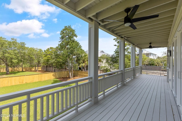 wooden deck with ceiling fan and a yard