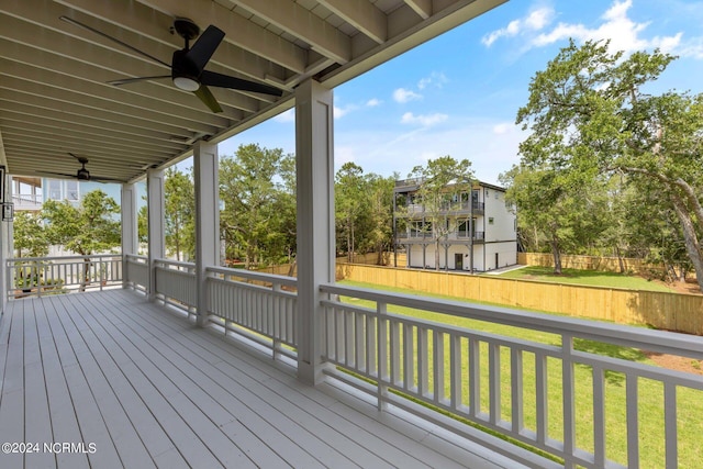 wooden deck with a lawn and ceiling fan