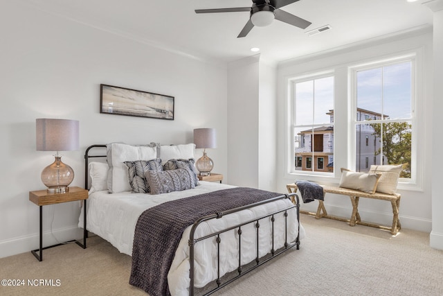 bedroom featuring ceiling fan, light colored carpet, and ornamental molding