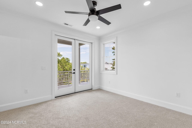 carpeted spare room with ceiling fan and french doors