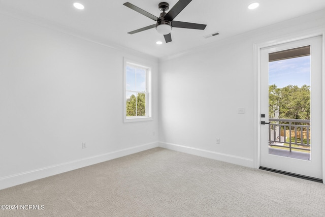 carpeted spare room with ceiling fan and crown molding