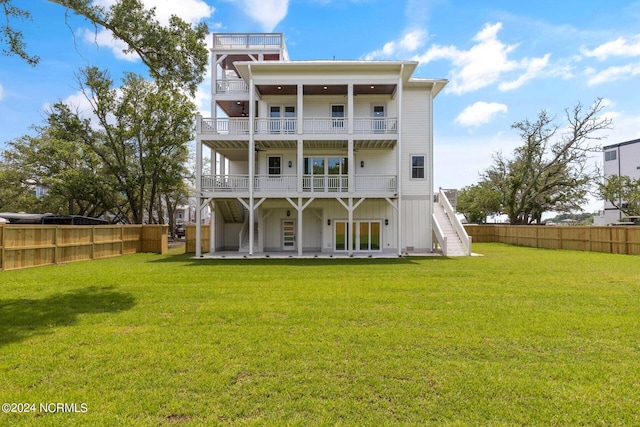 rear view of property with a lawn, a patio area, and a balcony