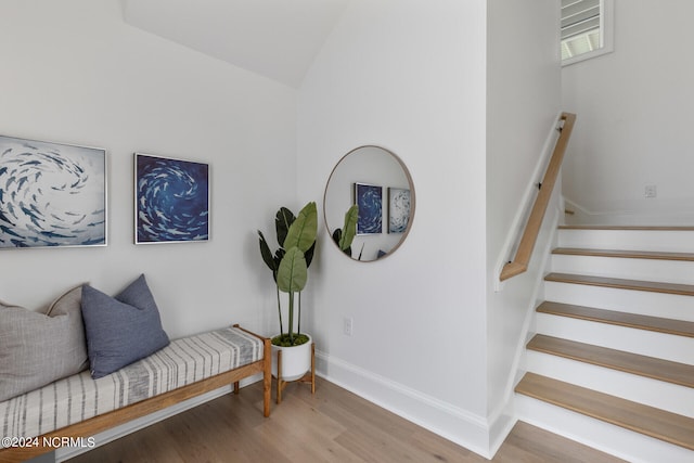 stairs featuring hardwood / wood-style floors and lofted ceiling