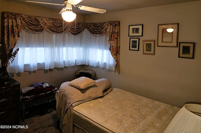 bedroom featuring ceiling fan, multiple windows, and carpet