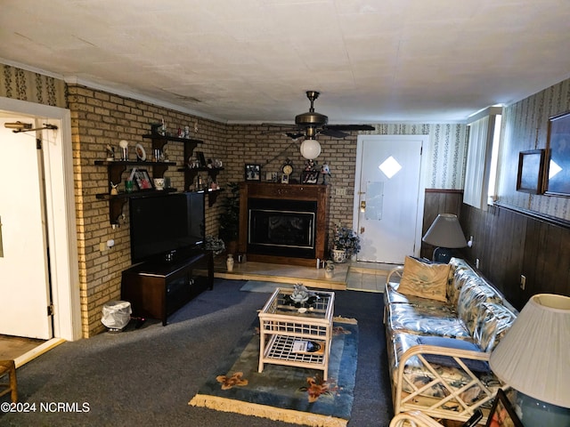 carpeted living room with ceiling fan, a large fireplace, and brick wall