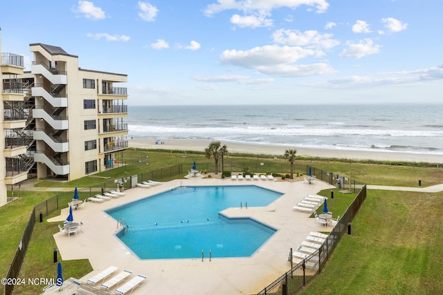 view of swimming pool featuring a lawn and a water view