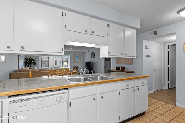 kitchen with light tile flooring, dishwasher, white cabinetry, sink, and a textured ceiling