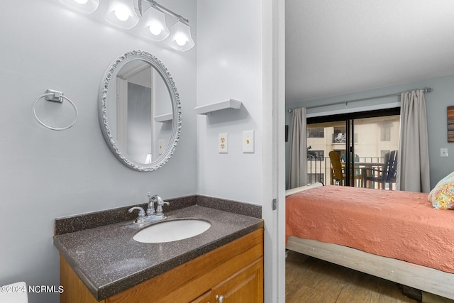 bathroom featuring hardwood / wood-style flooring and vanity with extensive cabinet space