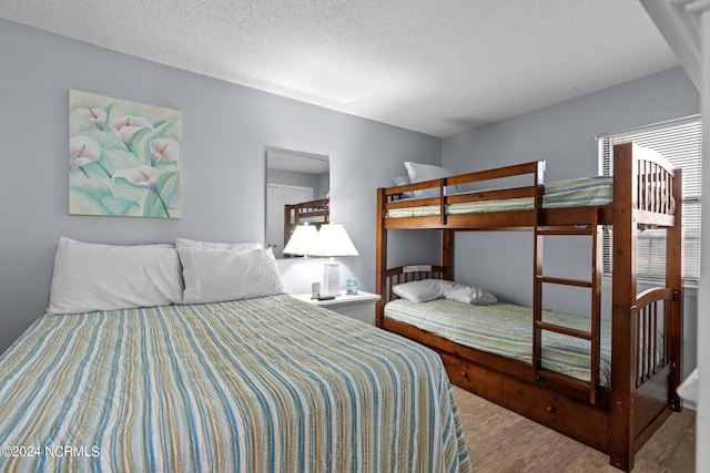 bedroom with wood-type flooring and a textured ceiling