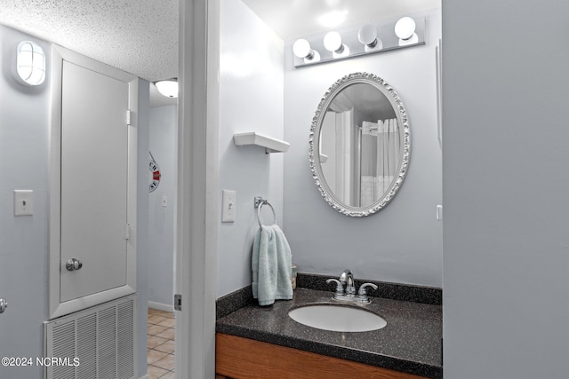 bathroom featuring tile floors, a textured ceiling, and large vanity