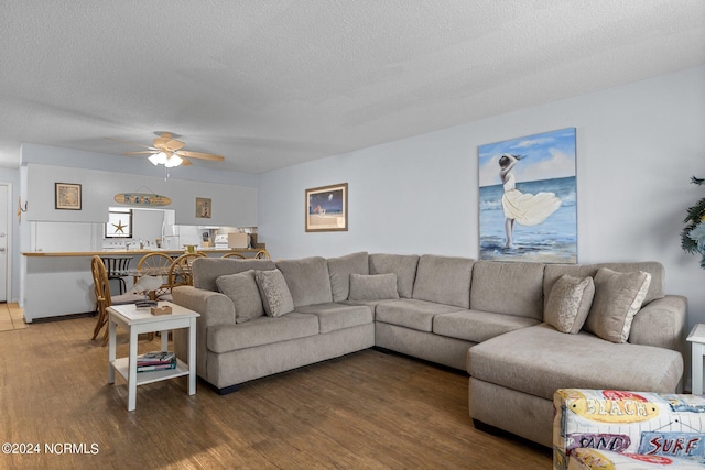 living room with ceiling fan, hardwood / wood-style flooring, and a textured ceiling