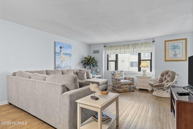 living room featuring a textured ceiling and light hardwood / wood-style flooring