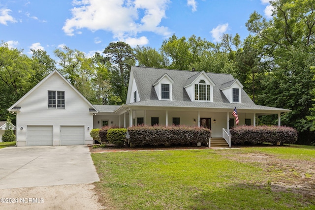 view of front of house featuring covered porch, a garage, and a front yard