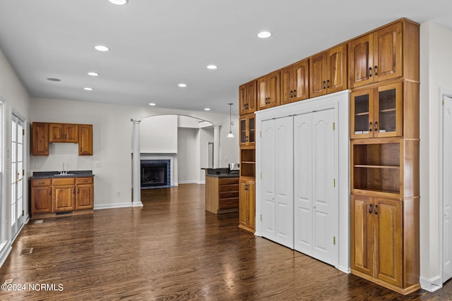 kitchen with decorative columns, sink, decorative light fixtures, and dark hardwood / wood-style floors