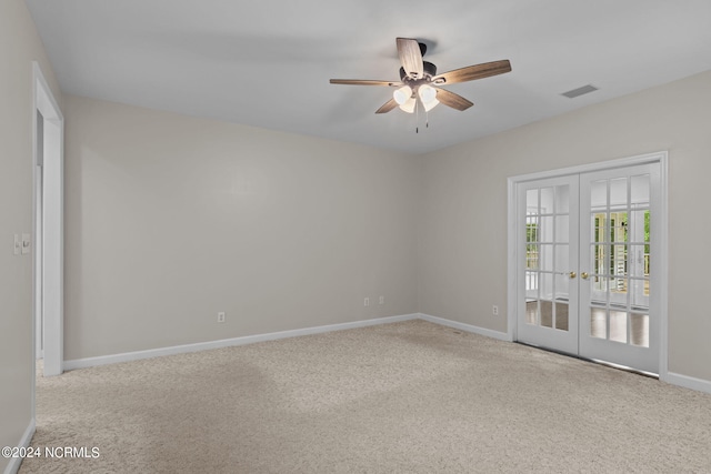 carpeted spare room with ceiling fan and french doors