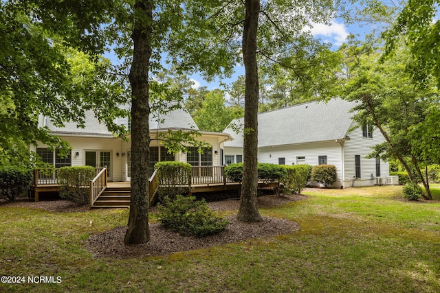 back of property featuring a lawn and a wooden deck