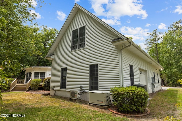 rear view of house featuring a yard, a deck, and central air condition unit