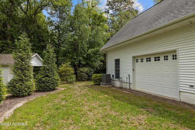 view of yard with a garage and central air condition unit