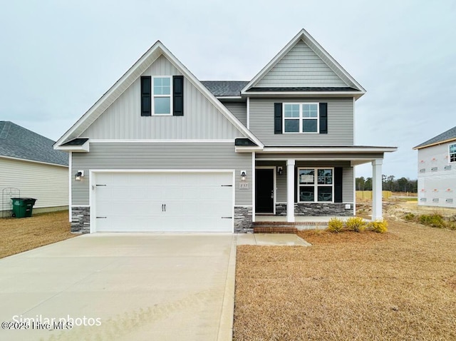 craftsman-style house with a front yard, covered porch, and a garage