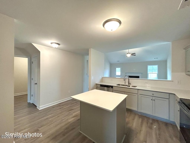 kitchen featuring dark wood-type flooring, dishwasher, electric range oven, a kitchen island, and sink