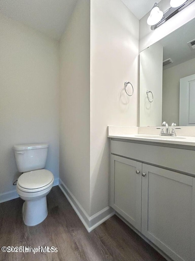 bathroom with toilet, wood-type flooring, and vanity