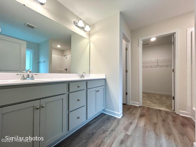 bathroom featuring a shower, hardwood / wood-style floors, and vanity