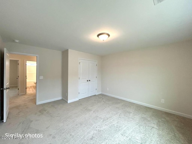 unfurnished bedroom featuring a closet and light carpet