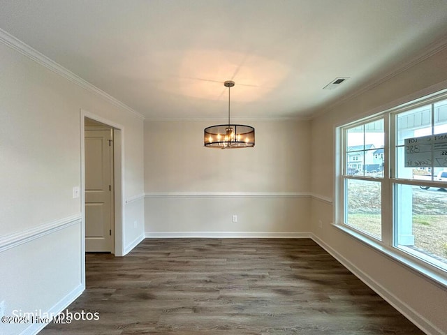 unfurnished room with ornamental molding, dark hardwood / wood-style flooring, an inviting chandelier, and a healthy amount of sunlight