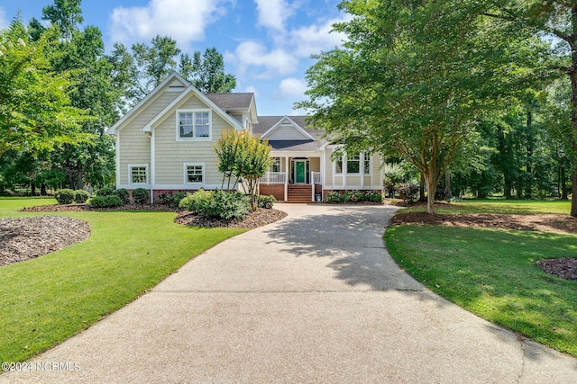 view of front of property featuring covered porch and a front lawn