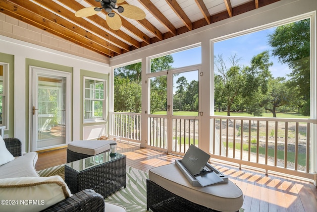 sunroom / solarium featuring vaulted ceiling with beams and ceiling fan