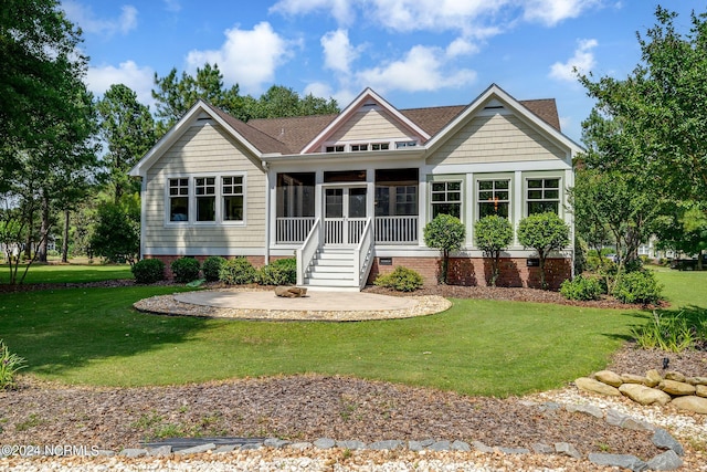 back of house featuring a lawn and a sunroom