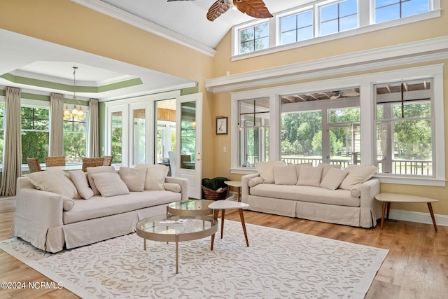 living room with ceiling fan, plenty of natural light, ornamental molding, and light wood-type flooring