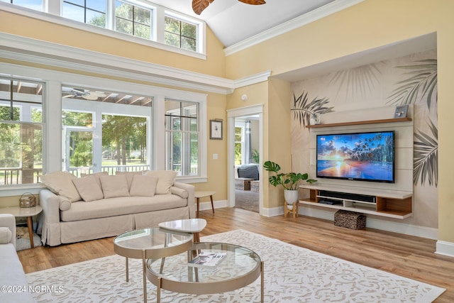 interior space featuring light wood-type flooring, high vaulted ceiling, ceiling fan, and crown molding