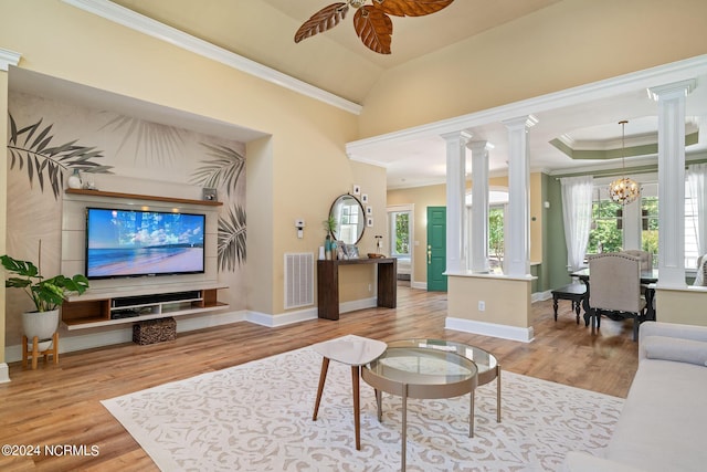 living room with ceiling fan with notable chandelier, crown molding, and light hardwood / wood-style flooring