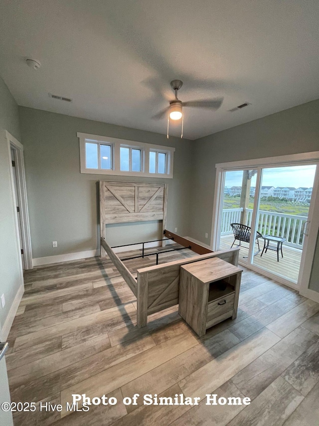 bedroom with access to exterior, visible vents, light wood-style floors, and baseboards