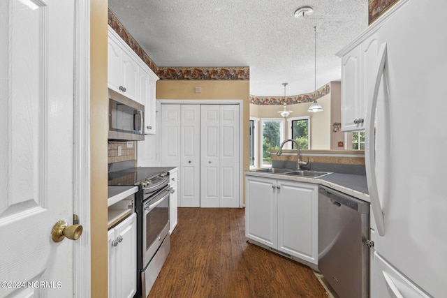 kitchen featuring appliances with stainless steel finishes, white cabinets, and a sink