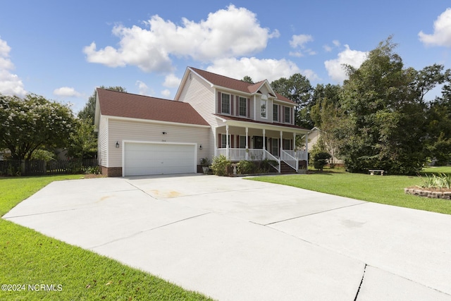 colonial house featuring a garage, driveway, a front lawn, and a porch